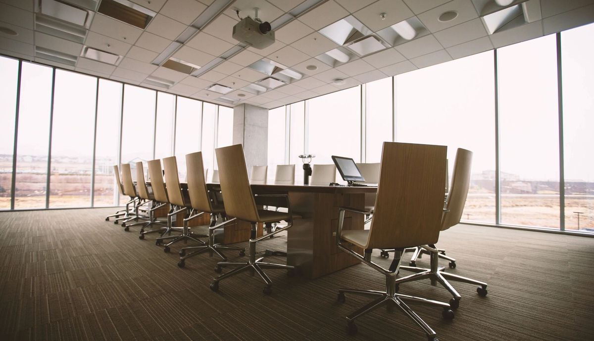 Boardroom table beside floor-to-ceiling windows